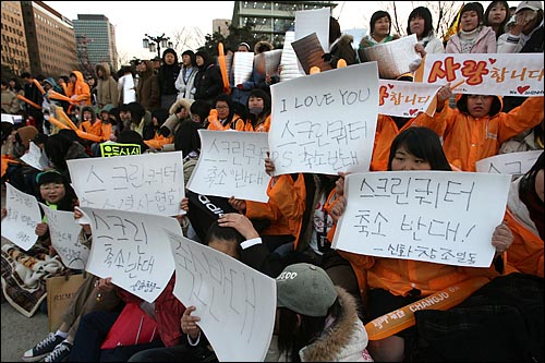 가수의 팬클럽 회원들이 종이 피켓을 들고 있다. 